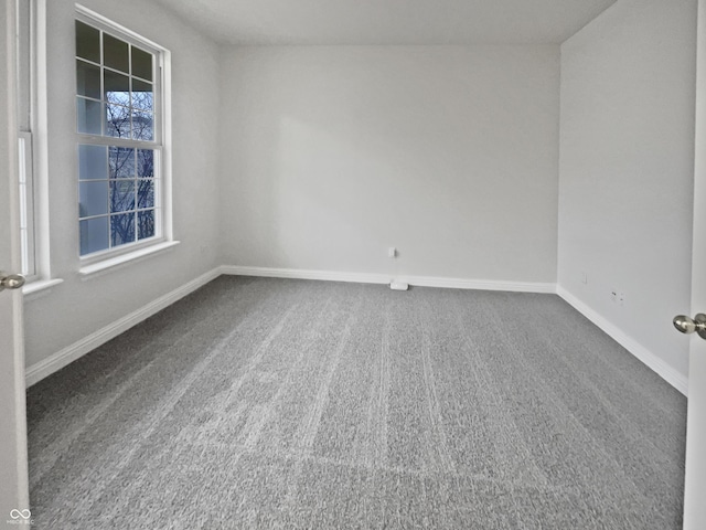 carpeted spare room featuring baseboards