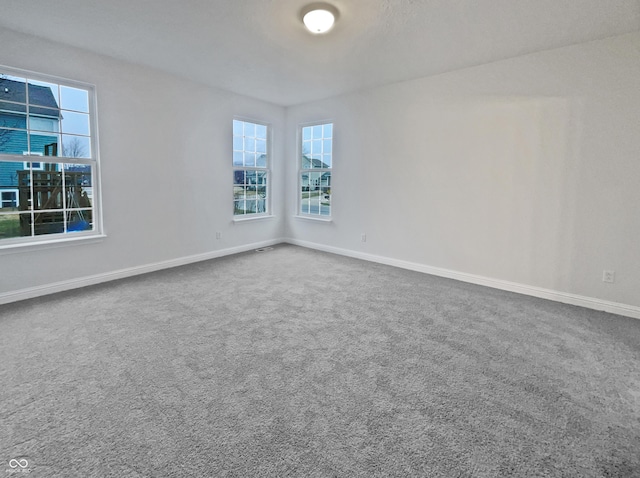 carpeted spare room featuring baseboards