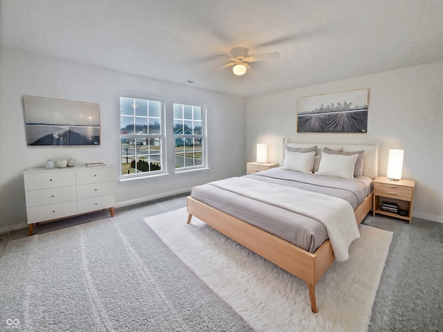 carpeted bedroom featuring ceiling fan and baseboards