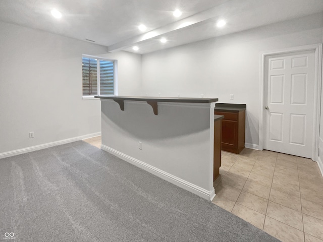 empty room with baseboards, light colored carpet, light tile patterned flooring, a bar, and recessed lighting