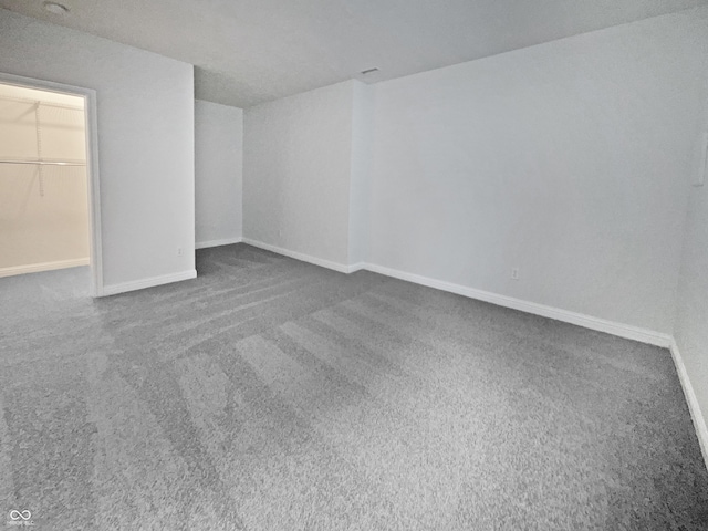 unfurnished bedroom with a spacious closet, baseboards, and carpet flooring