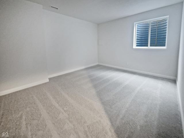 spare room with carpet and baseboards