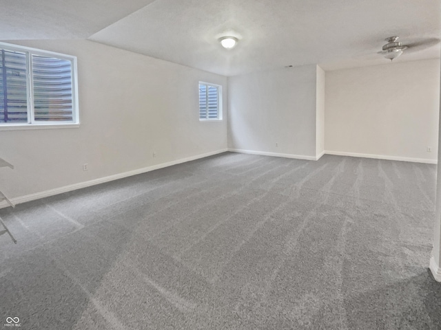 carpeted empty room featuring baseboards