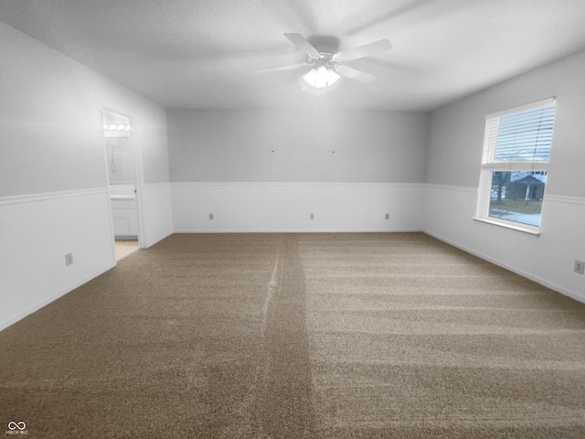 carpeted spare room with a ceiling fan