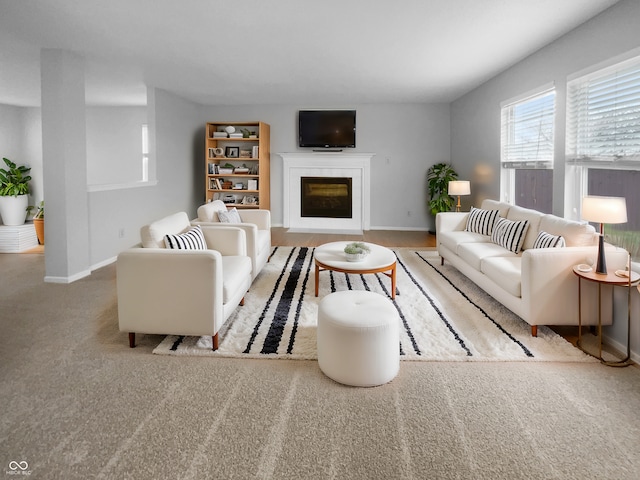 living room with a fireplace and baseboards