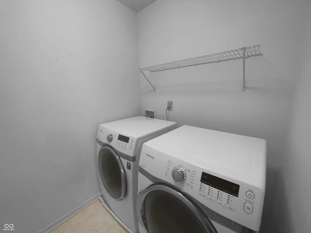 clothes washing area featuring laundry area, washing machine and dryer, and baseboards