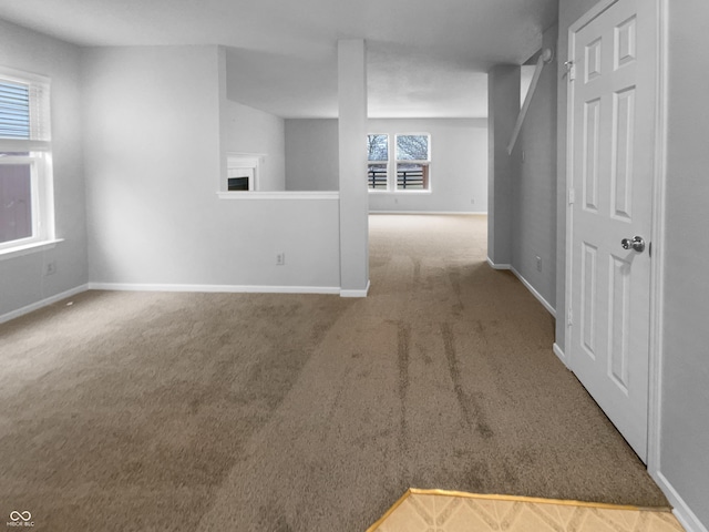 spare room featuring carpet floors and baseboards