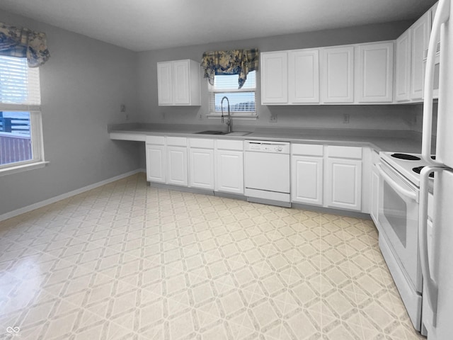 kitchen featuring white appliances, a sink, baseboards, white cabinets, and light floors