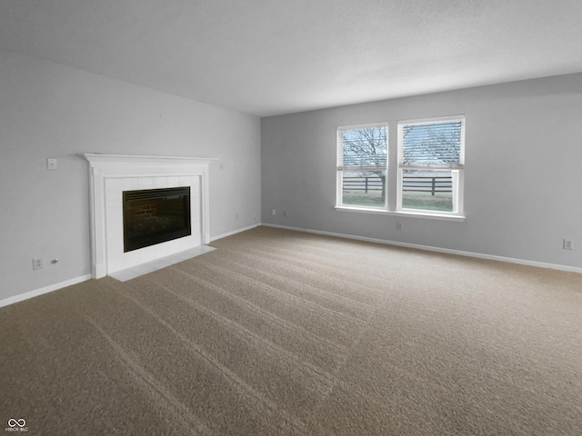 unfurnished living room featuring carpet floors, a fireplace, and baseboards