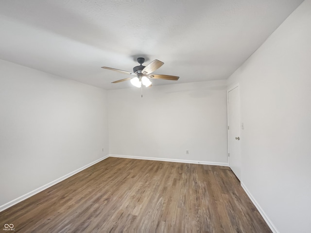 empty room featuring ceiling fan, baseboards, and wood finished floors