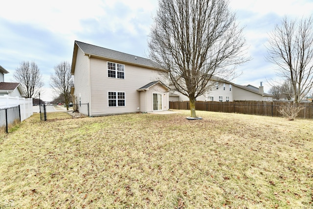 back of property with a yard, a patio area, and a fenced backyard