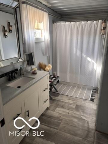 bathroom with vanity, a shower with shower curtain, and wood finished floors