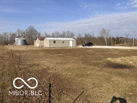 view of yard with an outbuilding and a rural view