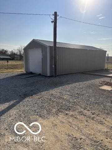 detached garage with gravel driveway