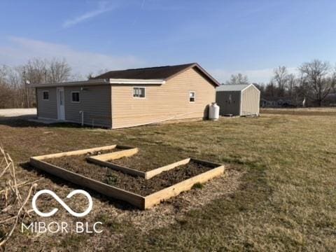 view of side of property with a yard, an outdoor structure, and a shed