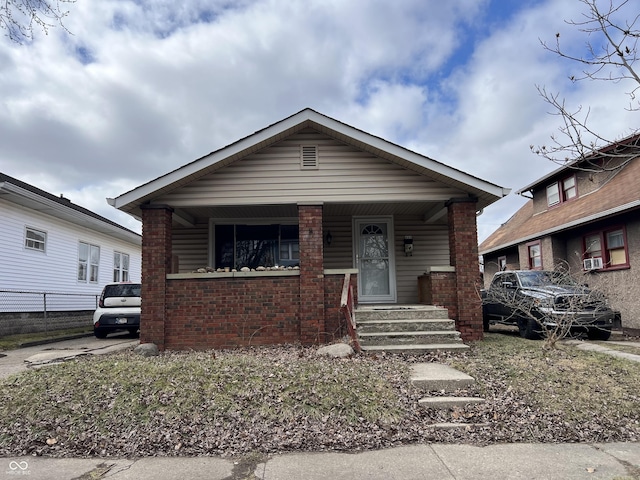 bungalow with a porch and brick siding