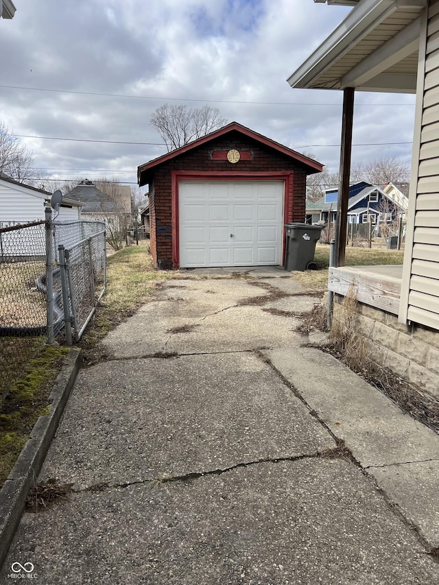 detached garage with fence and concrete driveway