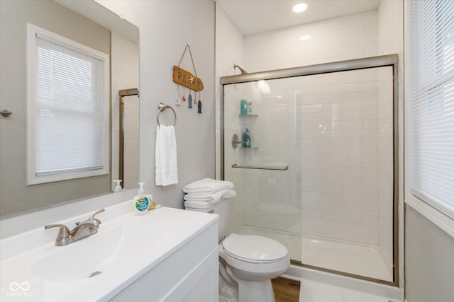 bathroom featuring a stall shower, vanity, and toilet