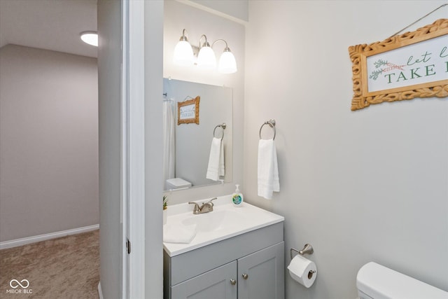 bathroom featuring vanity, toilet, and baseboards