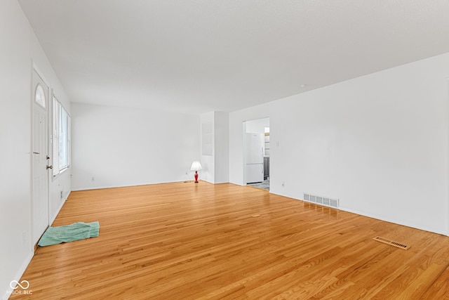 unfurnished living room with wood finished floors and visible vents