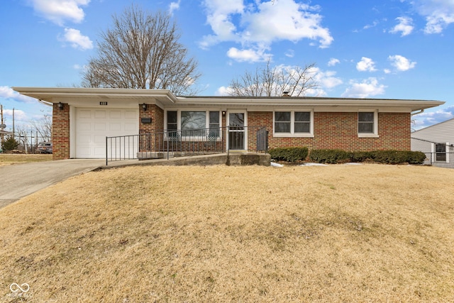 single story home with a garage, brick siding, driveway, and a front lawn