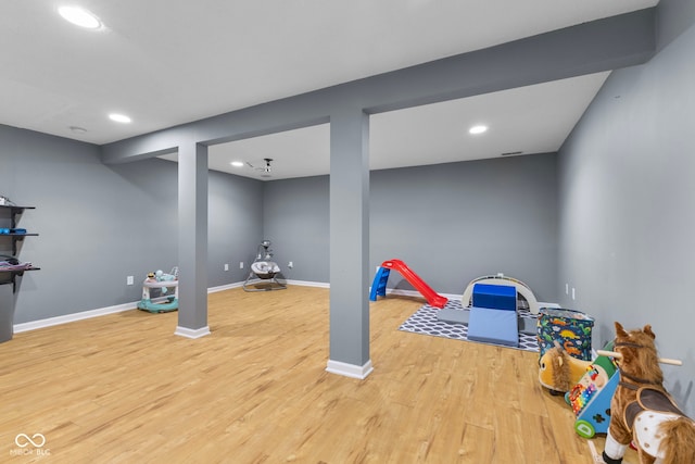 workout area with recessed lighting, baseboards, and light wood finished floors