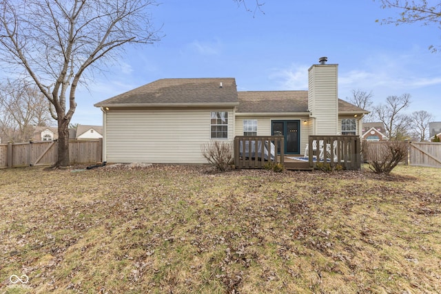 rear view of property featuring a gate, a chimney, a deck, and fence