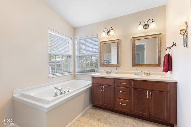 full bath featuring a garden tub, double vanity, and a sink