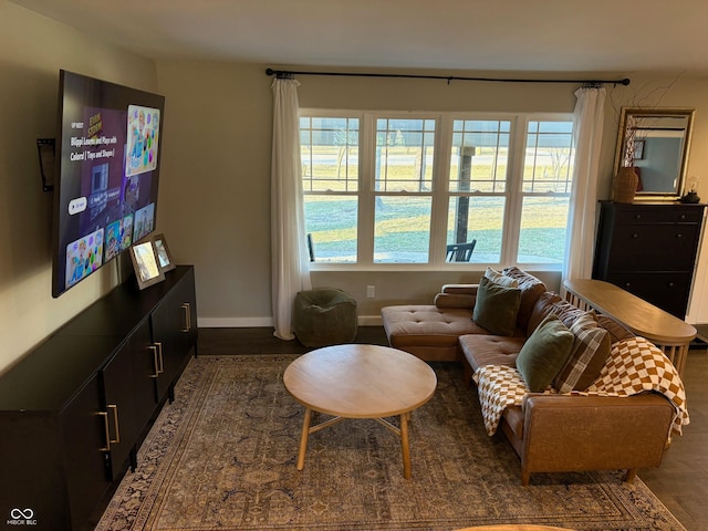 living area with baseboards and dark wood finished floors