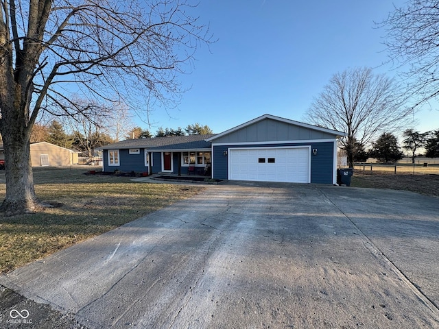 ranch-style home with board and batten siding, a front lawn, driveway, and a garage