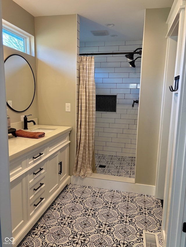 bathroom featuring visible vents, tiled shower, vanity, and tile patterned floors