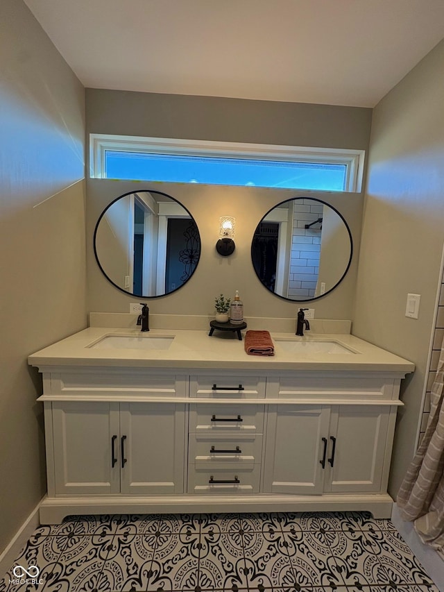 bathroom featuring double vanity, tile patterned flooring, and a sink