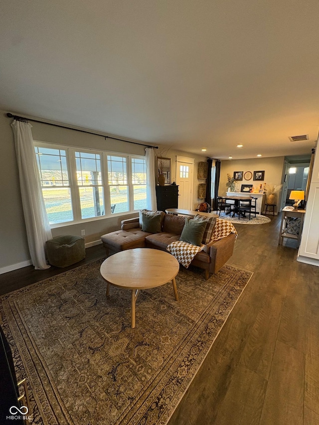 living area featuring recessed lighting, dark wood-style flooring, visible vents, and baseboards