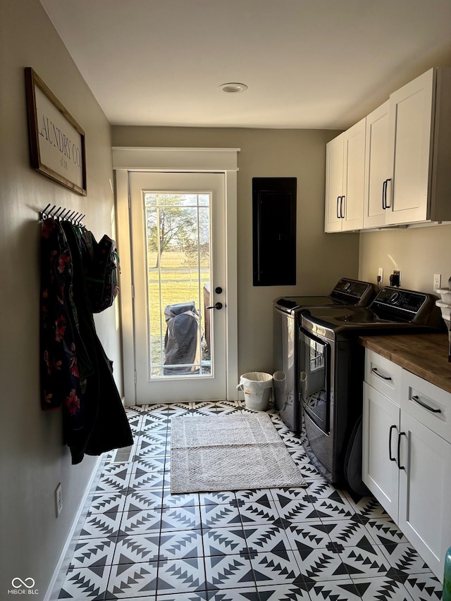 laundry room featuring baseboards, washer and clothes dryer, cabinet space, and electric panel