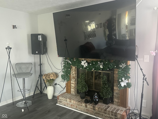 living room featuring a textured ceiling, wood finished floors, and baseboards