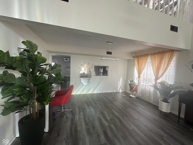 living room with wood finished floors, visible vents, and baseboards