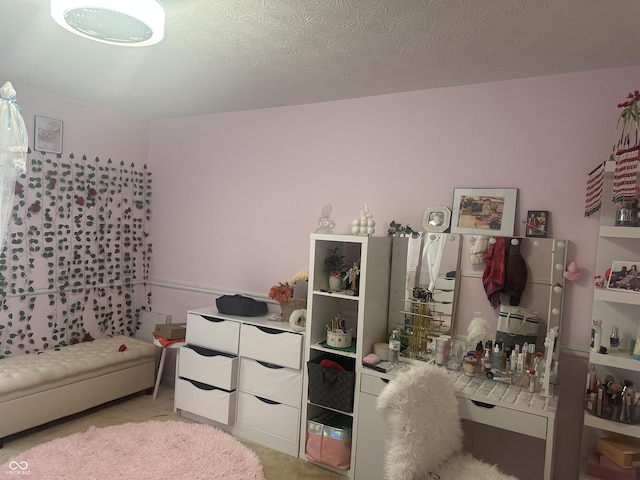 bedroom with a textured ceiling and light colored carpet