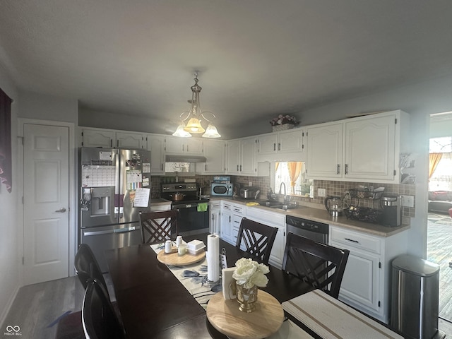 kitchen with backsplash, white cabinets, range with electric cooktop, under cabinet range hood, and stainless steel fridge with ice dispenser