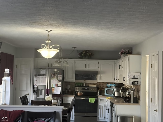 kitchen with under cabinet range hood, range with electric cooktop, white cabinetry, decorative backsplash, and stainless steel fridge