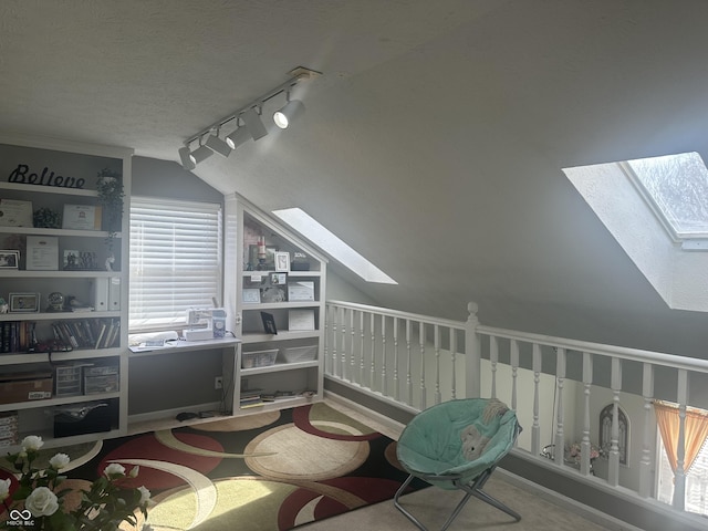 interior space featuring lofted ceiling with skylight and a textured ceiling