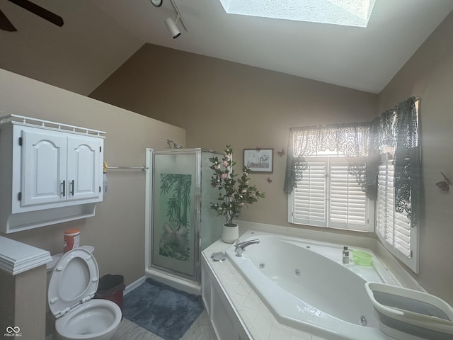 full bathroom with vaulted ceiling with skylight, toilet, a shower stall, and a whirlpool tub