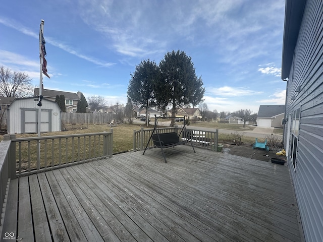 deck featuring an outdoor structure, a storage shed, and fence