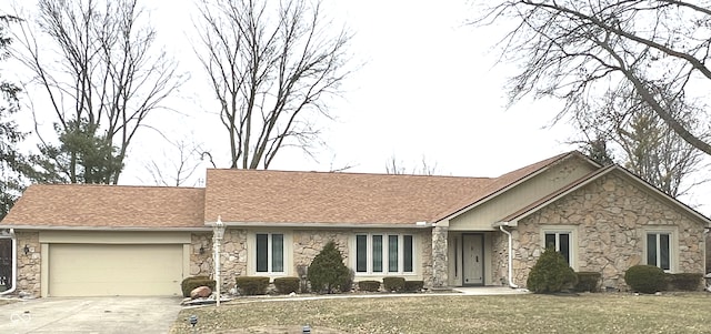 single story home featuring a garage, a shingled roof, concrete driveway, stone siding, and a front lawn