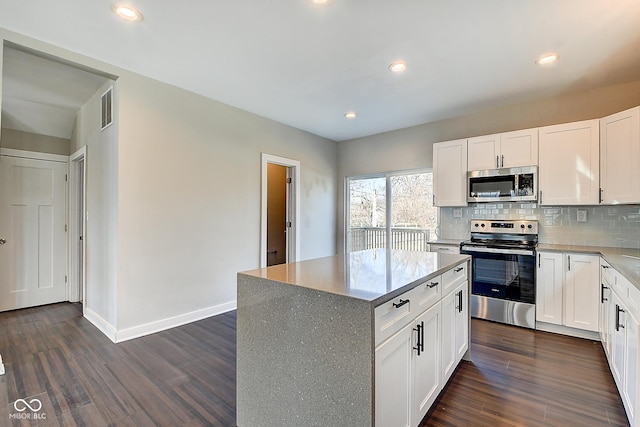 2308 Nowland Ave, Indianapolis, IN 46201 - kitchen with dark wood-style flooring, visible vents, baseboards, appliances with stainless steel finishes, and decorative backsplash