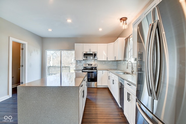 2308 Nowland Ave, Indianapolis, IN 46201 - kitchen featuring decorative backsplash, dark wood-style flooring, a center island, stainless steel appliances, and a sink