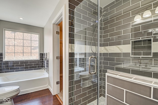 2308 Nowland Ave, Indianapolis, IN 46201 - bathroom featuring a tub to relax in, tiled shower, toilet, and wood finished floors