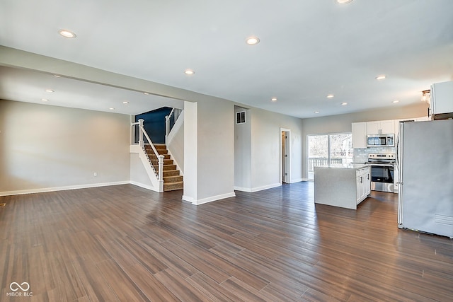 2308 Nowland Ave, Indianapolis, IN 46201 - unfurnished living room featuring recessed lighting, visible vents, baseboards, stairs, and dark wood-style floors