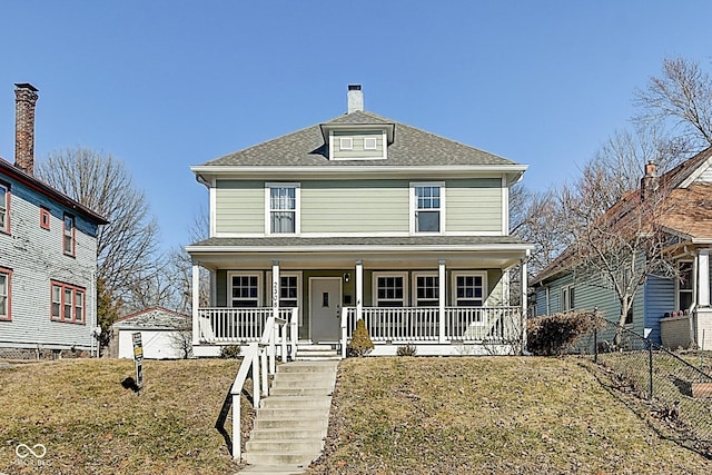 traditional style home with covered porch, roof with shingles, a front yard, and fence