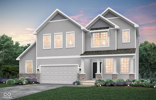 craftsman house featuring concrete driveway, roof with shingles, an attached garage, a yard, and board and batten siding