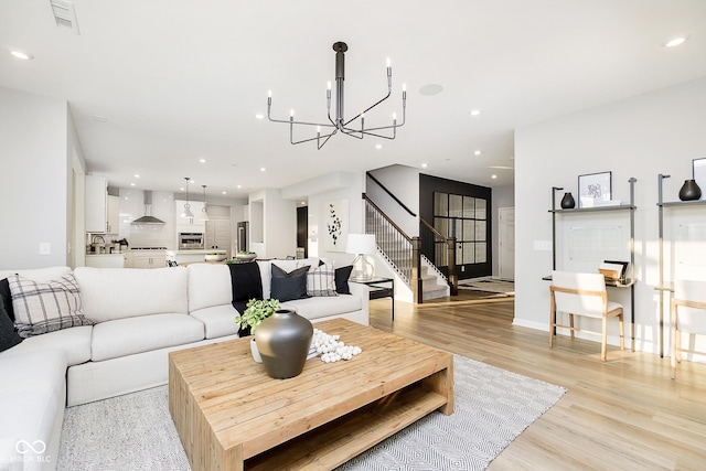 living room with stairway, visible vents, light wood-style floors, and recessed lighting